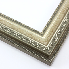 This highly detailed, solid wood frame features three distinct designs.  The dominant design tops a deep scoop of smooth, brushed silver foil and meets a small detail on the inner lip.  A drop ledge on the outer edge is decorated in a simple dash.  Matte areas within the designs create an antiqued look.

2 " width: ideal for medium- to large-size images. The detailed nature of this frame makes it suitable for bright or busy paintings or photographs.  It may overpower simpler images.