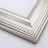 This high swan profile wood frame features a reverse slope and 1.5 " maximum depth.  The gentle ridges are encased in glossy silver foil - an elegant but simple design.

2.5 " width: ideal for medium and large images.  Pair with old, grayscale portraits and bold paintings or Giclée prints.