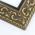 A large, reverse curve profile frame with an intricate leaf design bordered by a geometric outer edge and beaded inner lip. A dark, matte gold-brown base with gold foil patina for added depth on the topmost points of the design. Strong, solid wood construction.
3.25 " witdth: ideal for large and oversize (extra large) images.